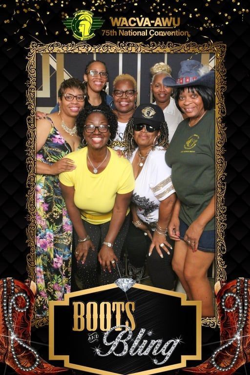 Six smiling people posing at a Roots & Bling event backdrop with gold and black decor.