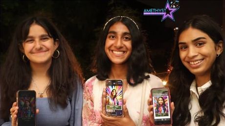 Three smiling people hold phones with colorful screens against a dark background.