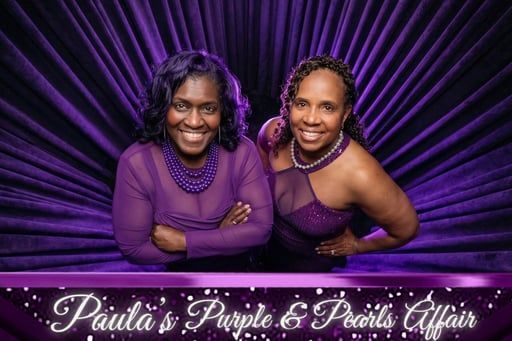 Two women in purple outfits pose smiling against a purple radial background with “Paula’s Purple & Pearls Affair” text.