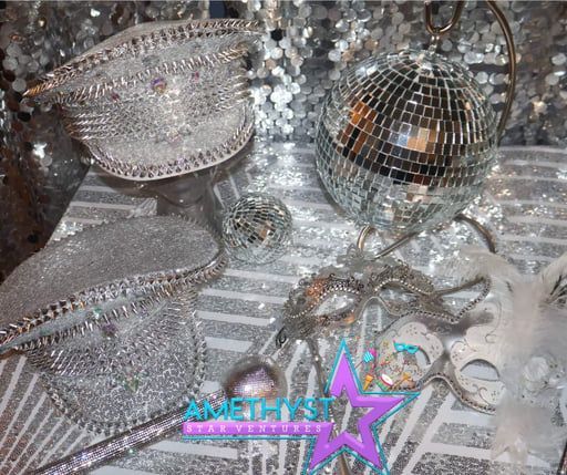 Silver disco decor and mirrored spheres with an AMETHYST star logo on a glittery surface