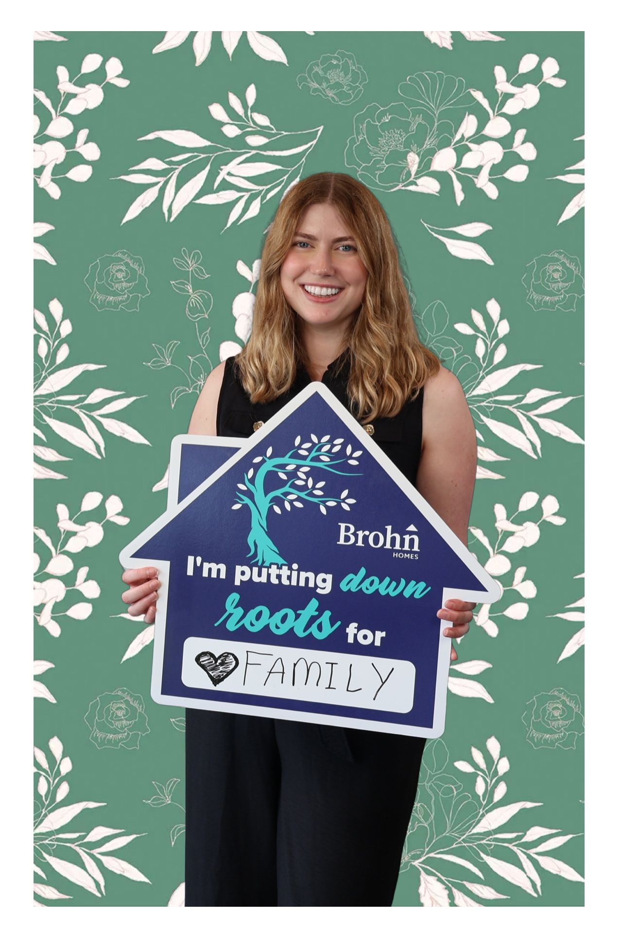 Guest holding a personalized message in a branded Brohn Homes event portrait