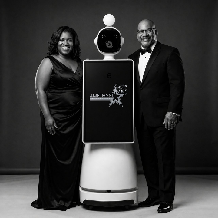 African American couple posing beside Starla, the Amethyst Star Ventures roaming robot photo booth
