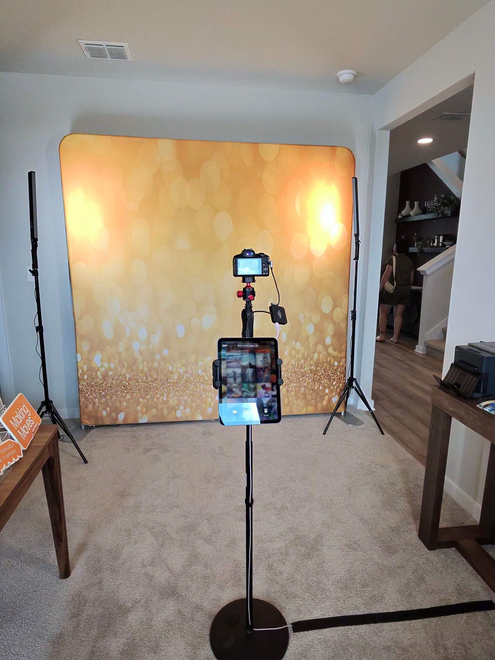 Photo booth setup with gold backdrop at the Brohn Homes Legacy Hills grand opening in Mico, Texas