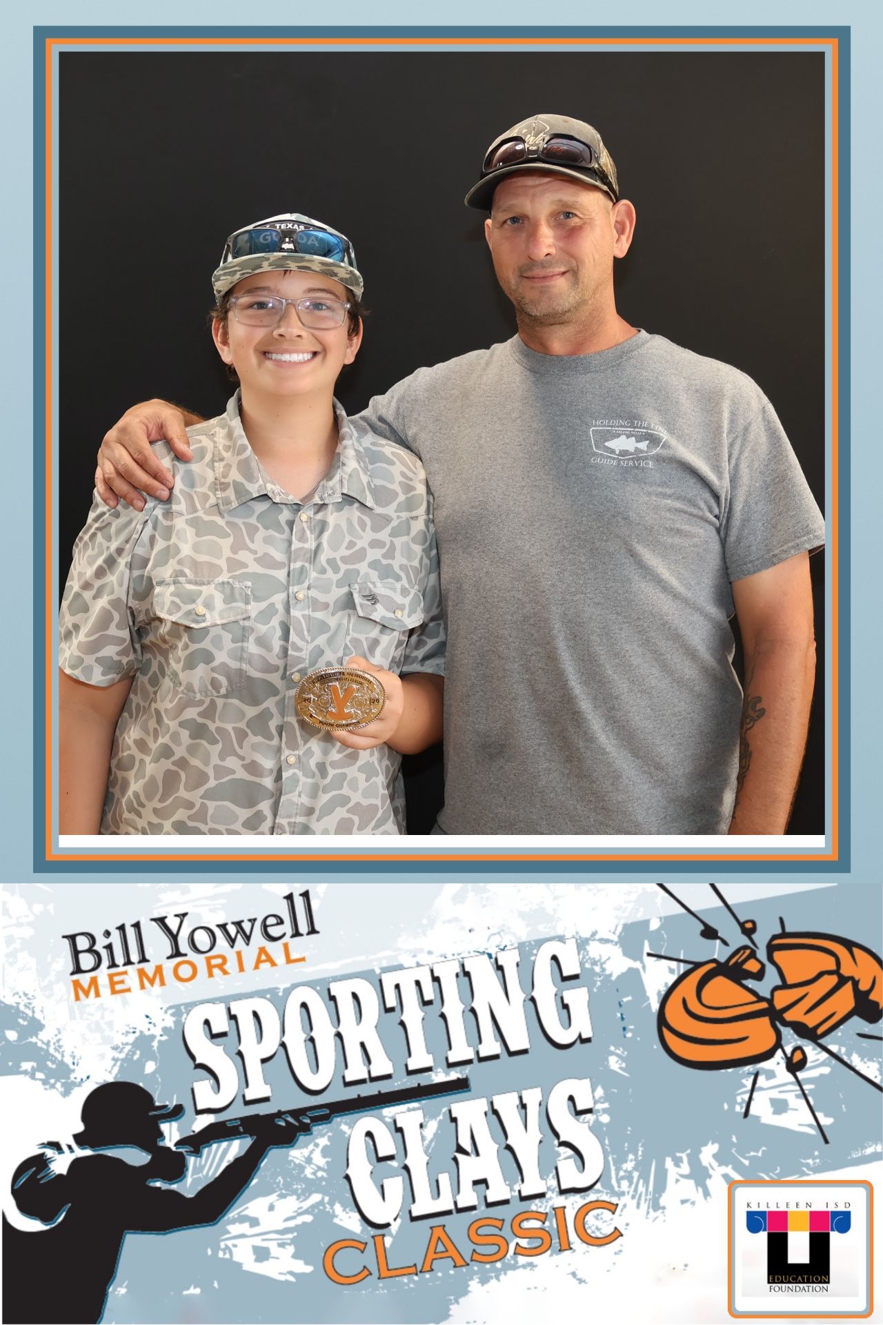 Two guests posing in the Bill Yowell Memorial Sporting Clays Classic photo frame