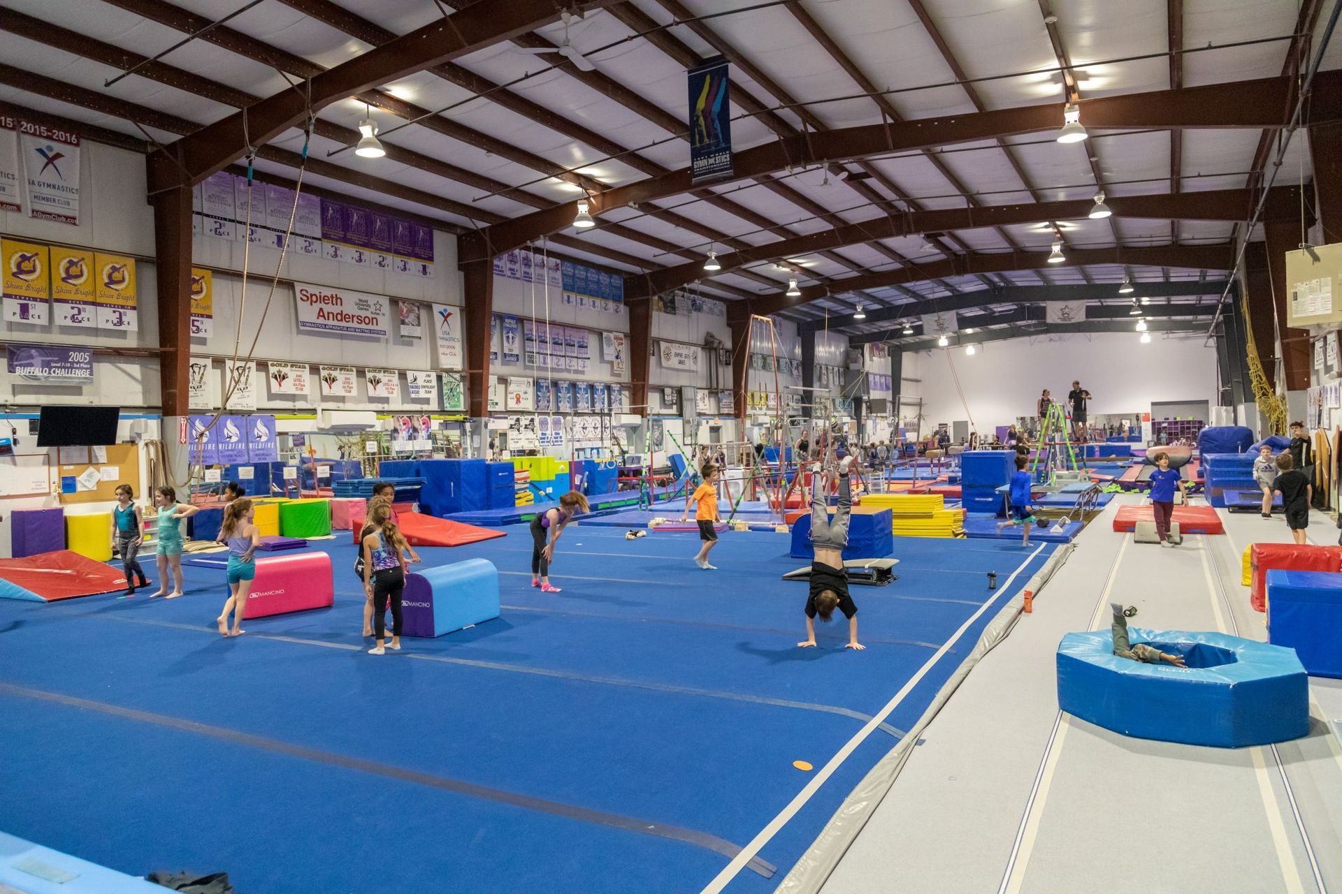 A large gym filled with people doing exercises on the floor.