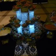Decorated buffet table with glowing blue centerpieces, flowers, and patterned table runner