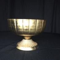 Gold decorative bowl on a pedestal against a dark background