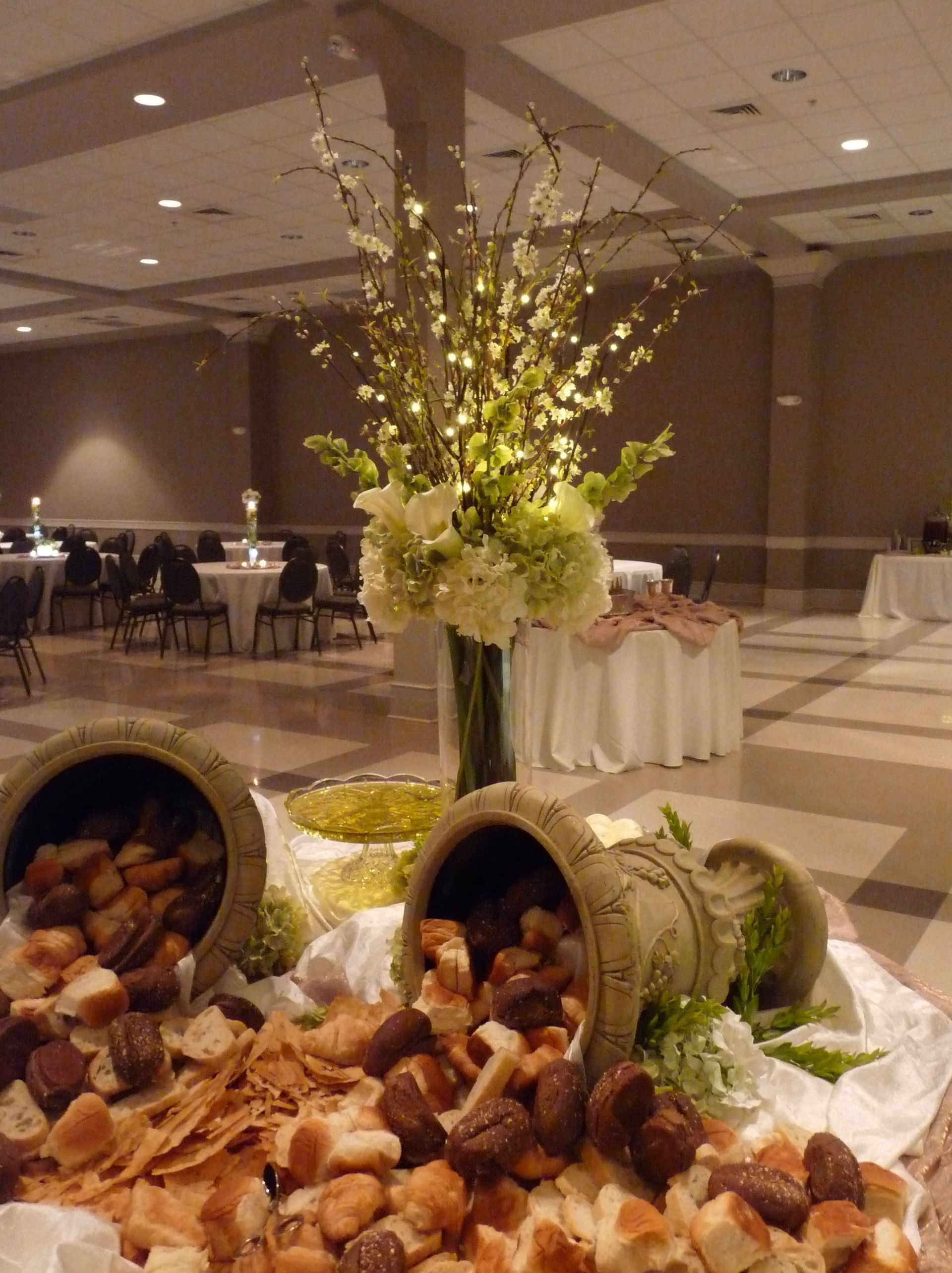 Elegant banquet table with floral centerpiece and baskets of bread in a formal reception hall