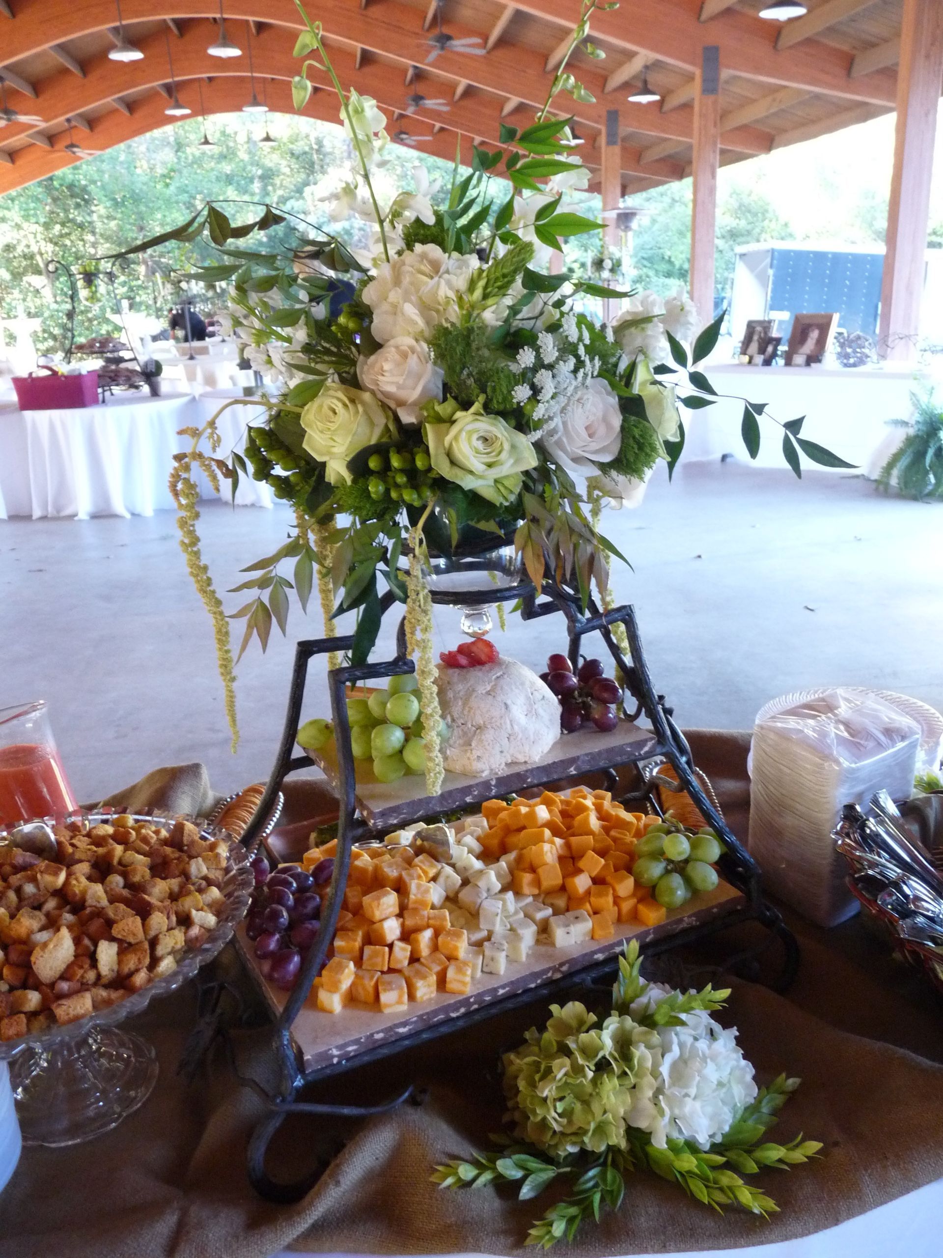 Tiered dessert table with flowers and assorted sweets in an open-air venue