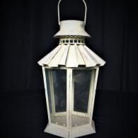 White metal hanging lantern with glass panels on a dark background