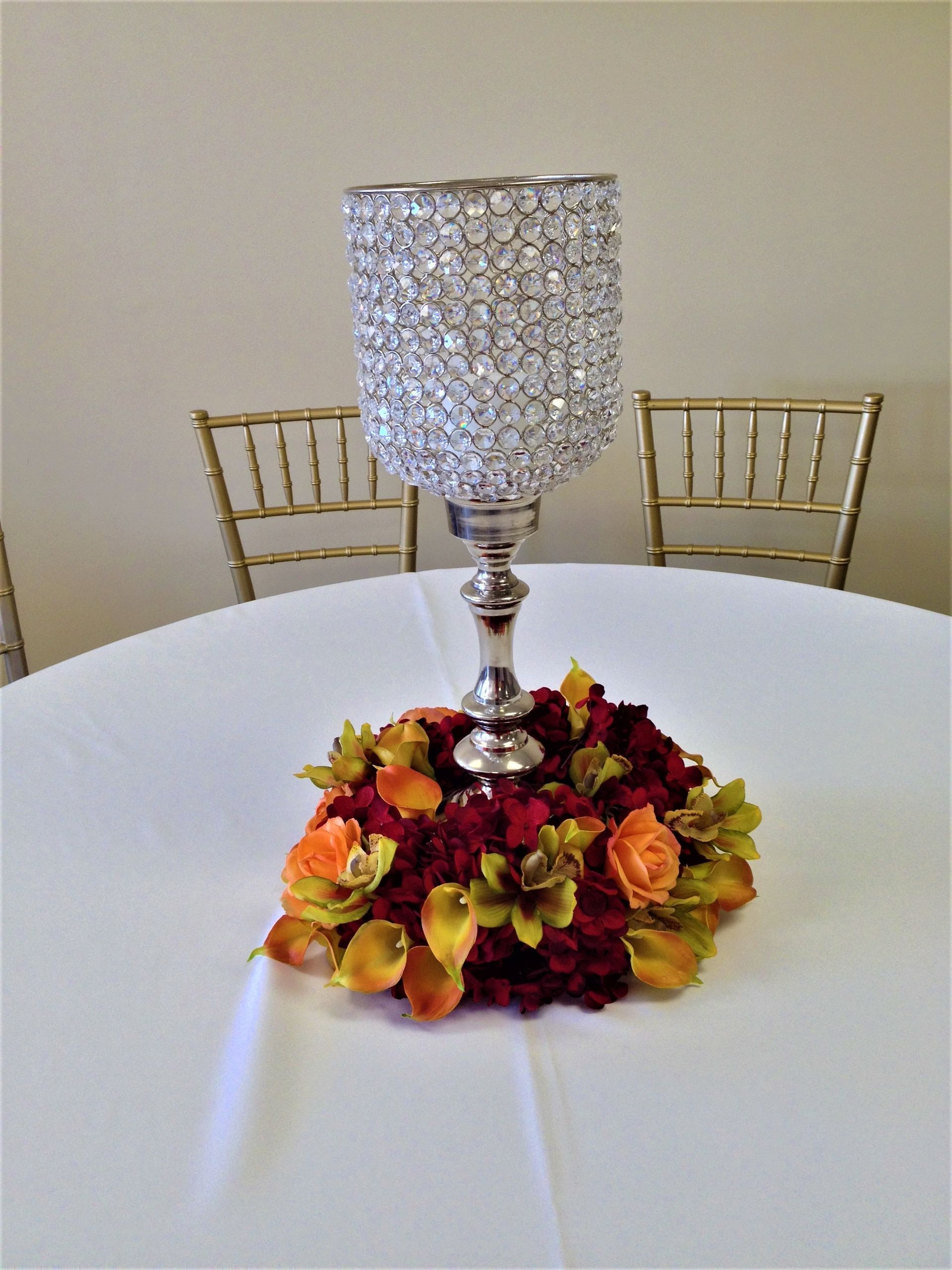 Silver crystal vase with autumn flowers centerpiece on a white table in a dining room