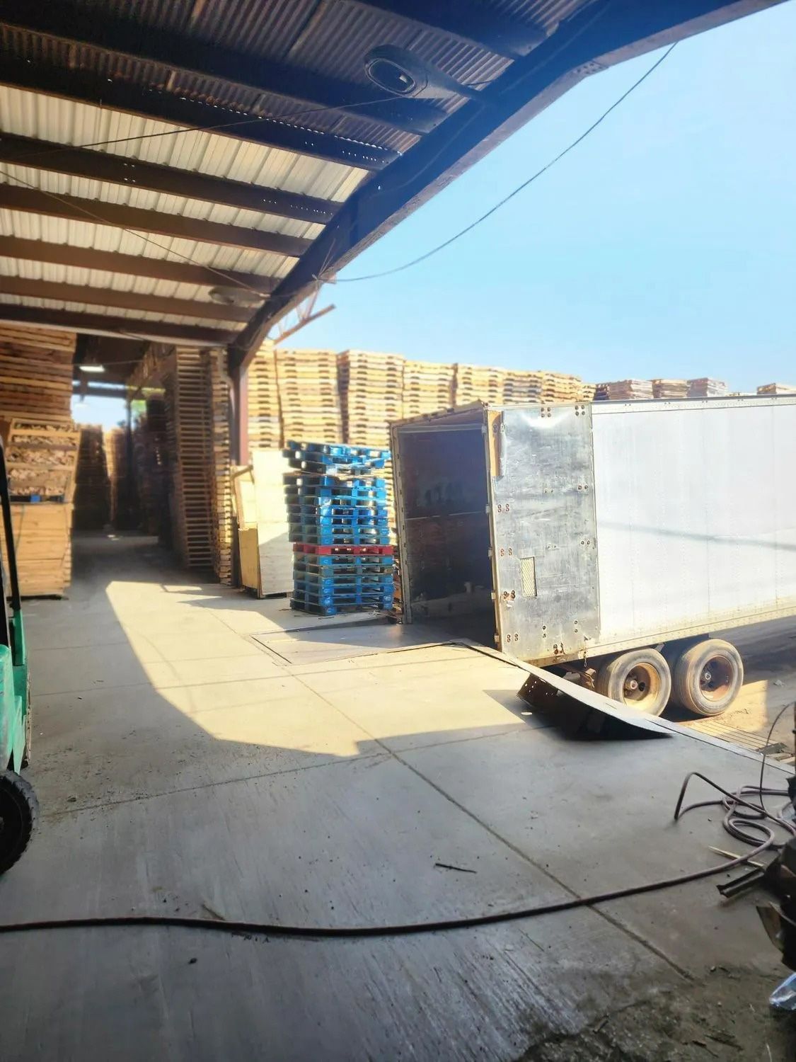 A warehouse filled with lots of pallets and a truck.