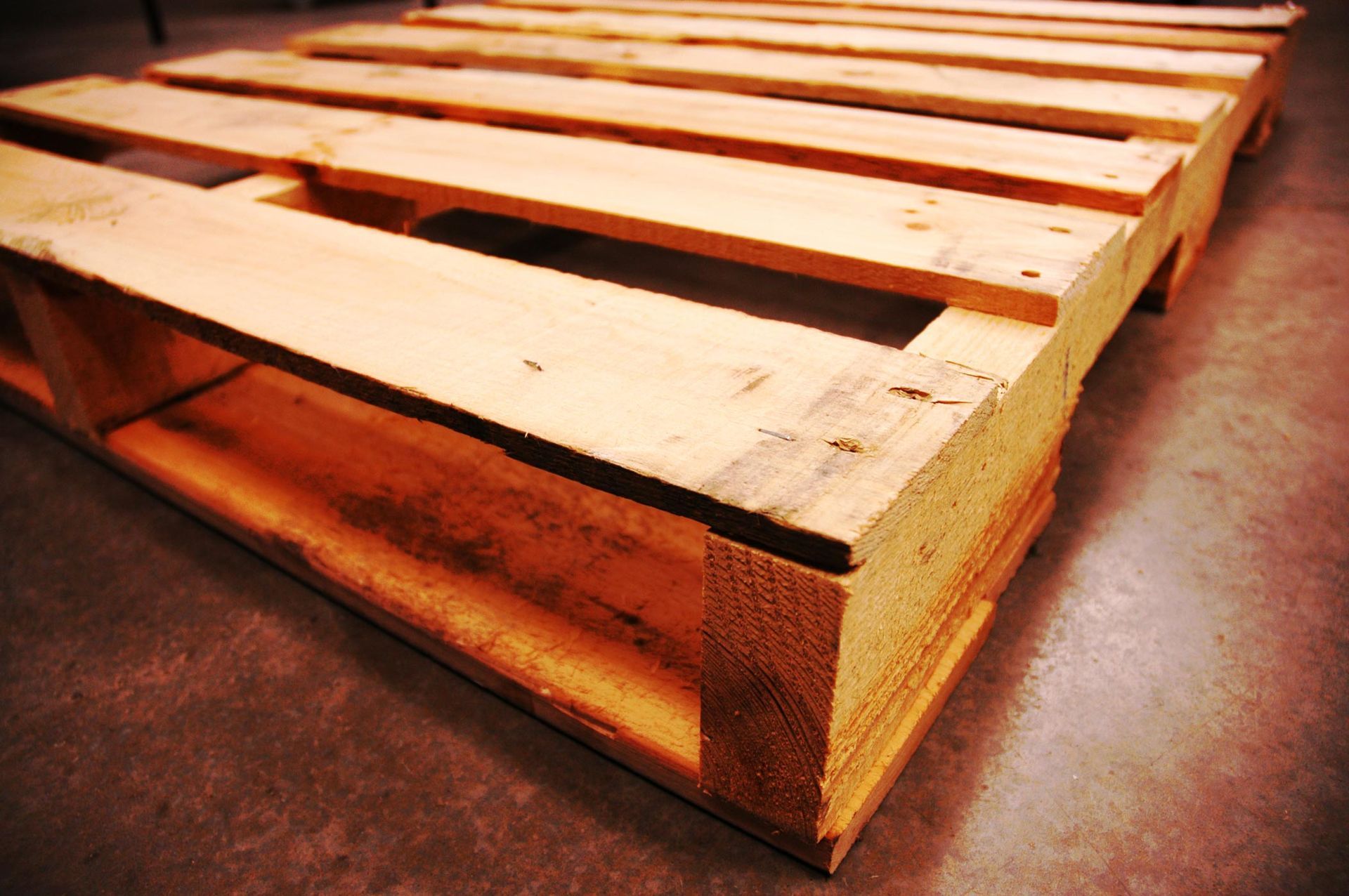 A wooden pallet is sitting on a concrete floor