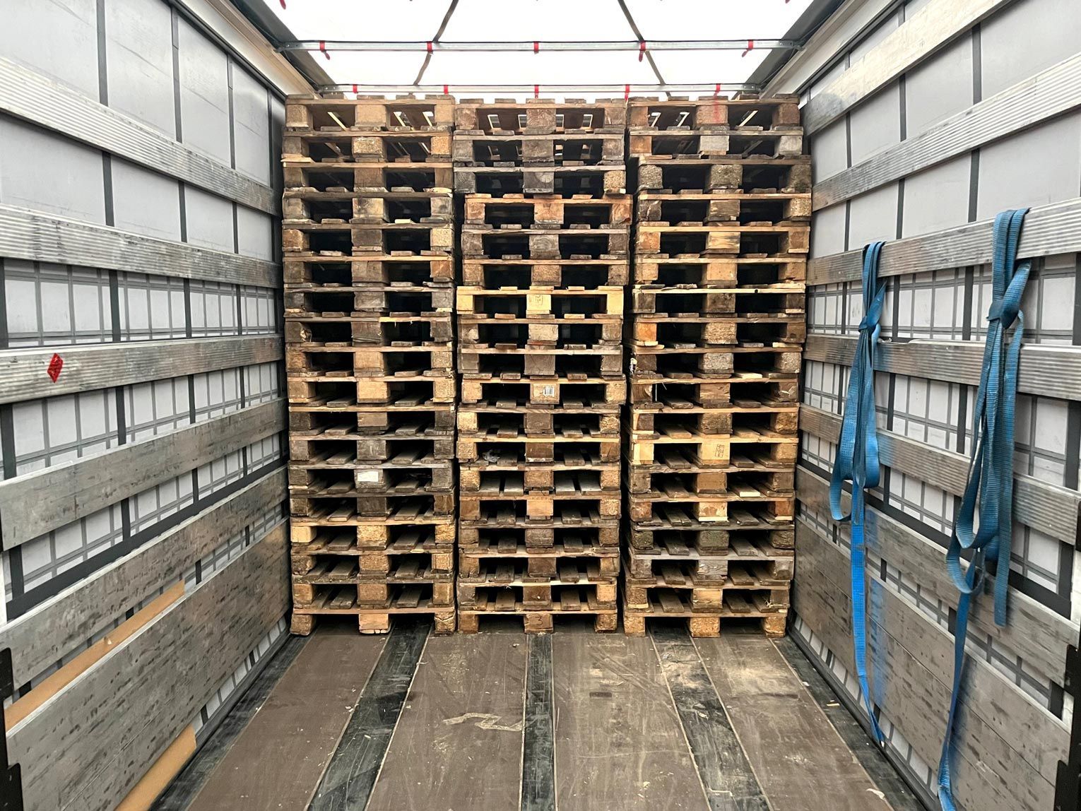 A stack of wooden pallets in the back of a truck.