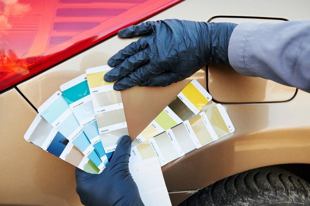 A Person Is Holding A Color Palette In Front Of A Car — K & D Auto Repair in Cardiff, NSW