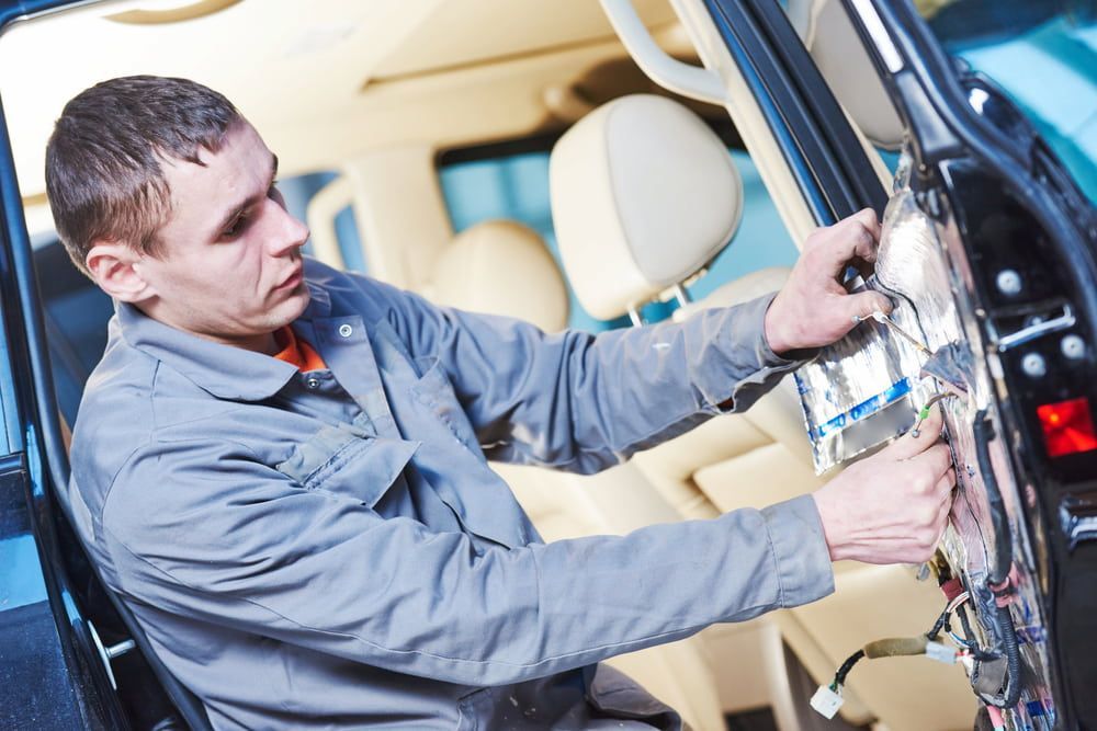 A Man Is Working On The Inside Of A Car — K & D Auto Repair in Cardiff, NSW