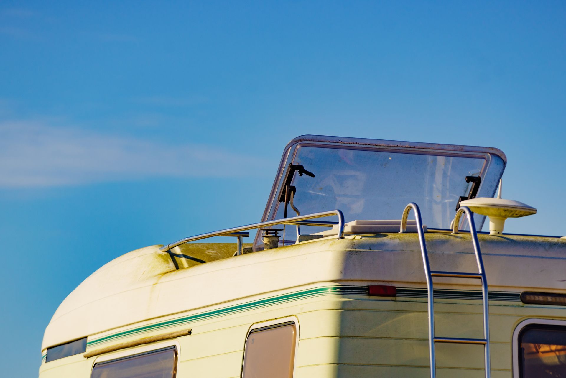 White and Green Camper Against a Bright Blue Sky — Darren's Caravan Repairs in Warners Bay, NSW