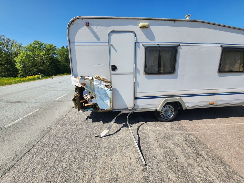 Damaged White Travel Trailer on the Side of a Road After an Accident — Darren's Caravan Repairs in Warners Bay, NSW