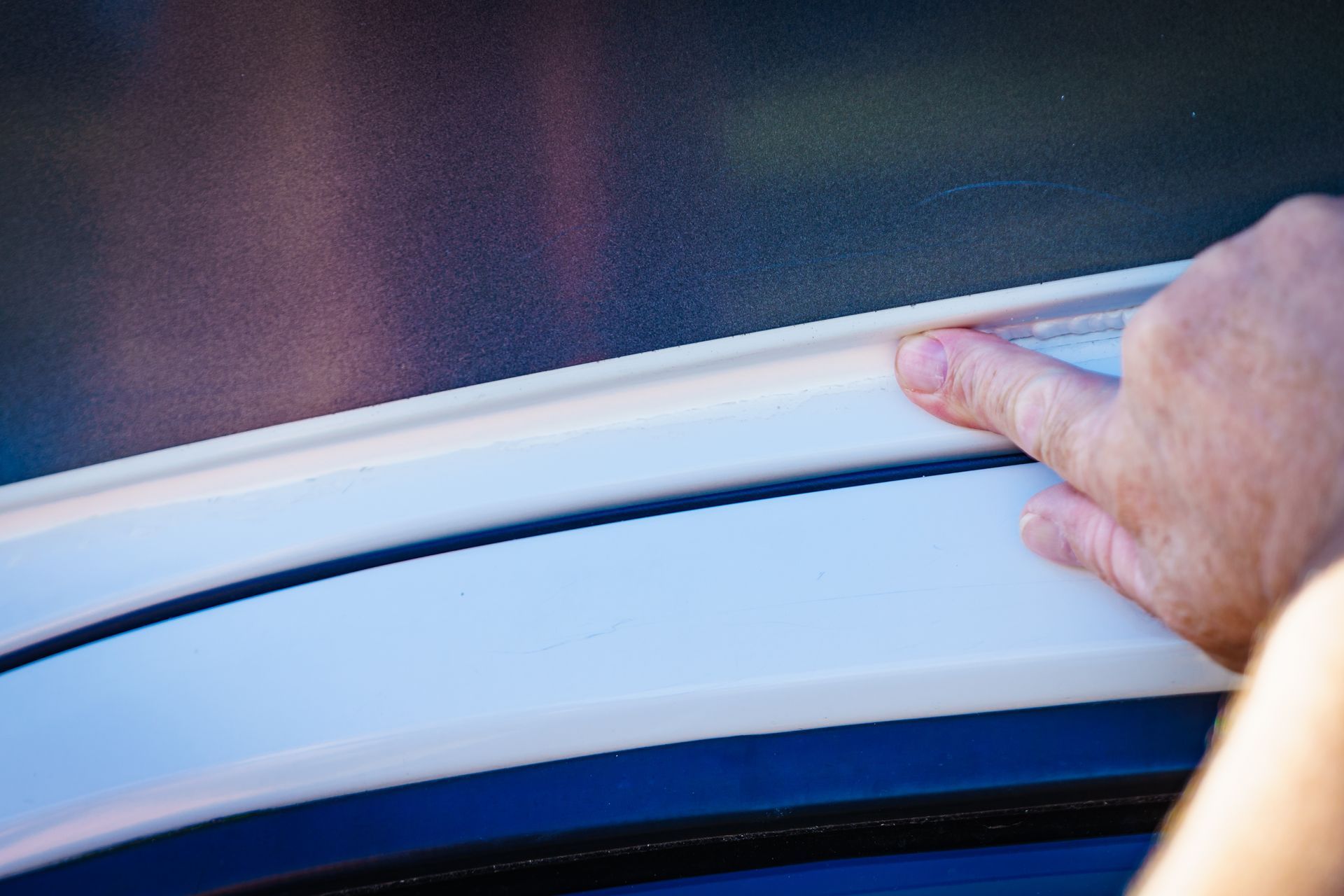 Finger Pointing at White Sealant on a Vehicle — Darren's Caravan Repairs in Warners Bay, NSW