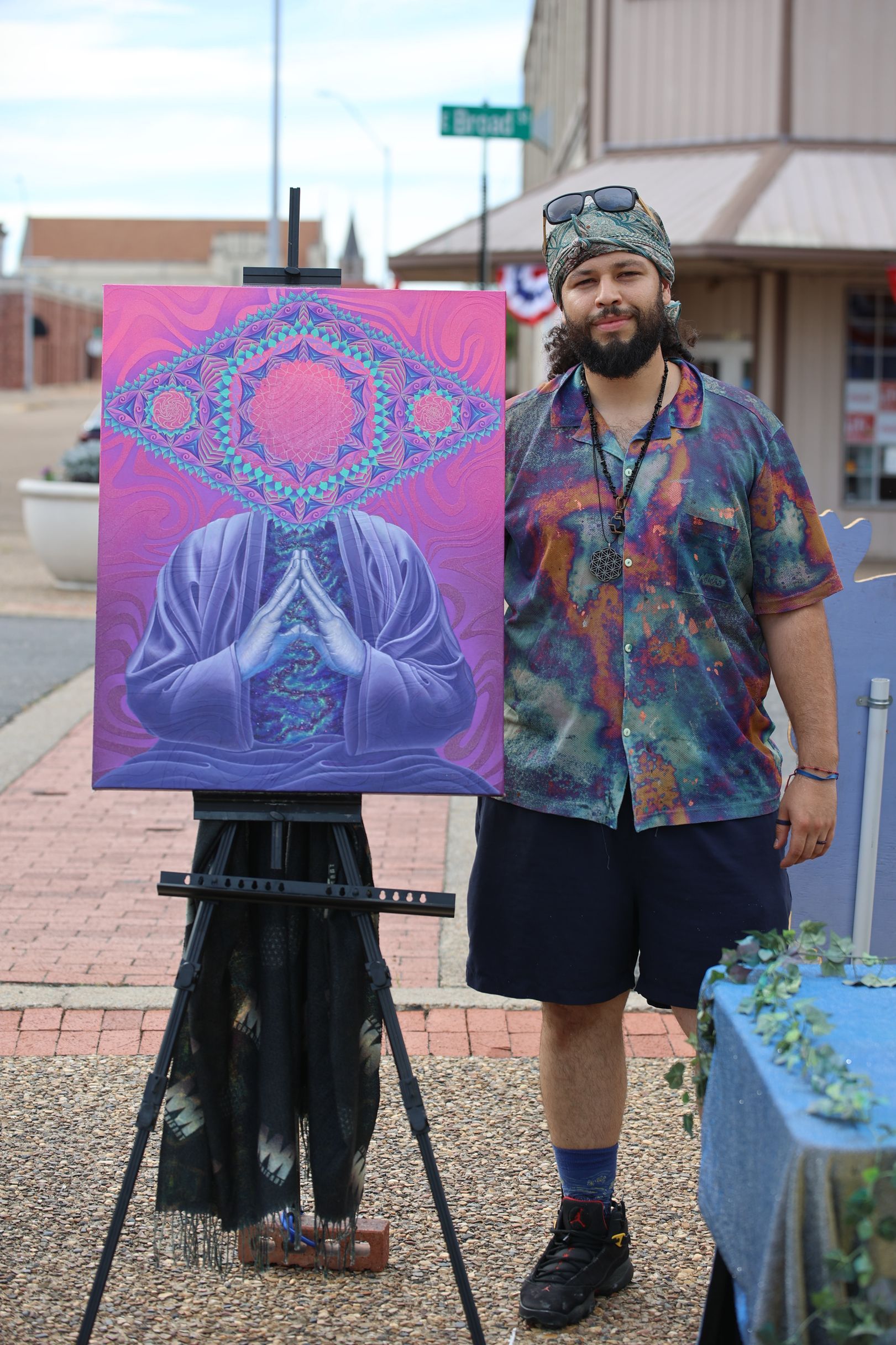 Man standing beside a colorful abstract painting in downtown Texarkana during Downtown LIVE