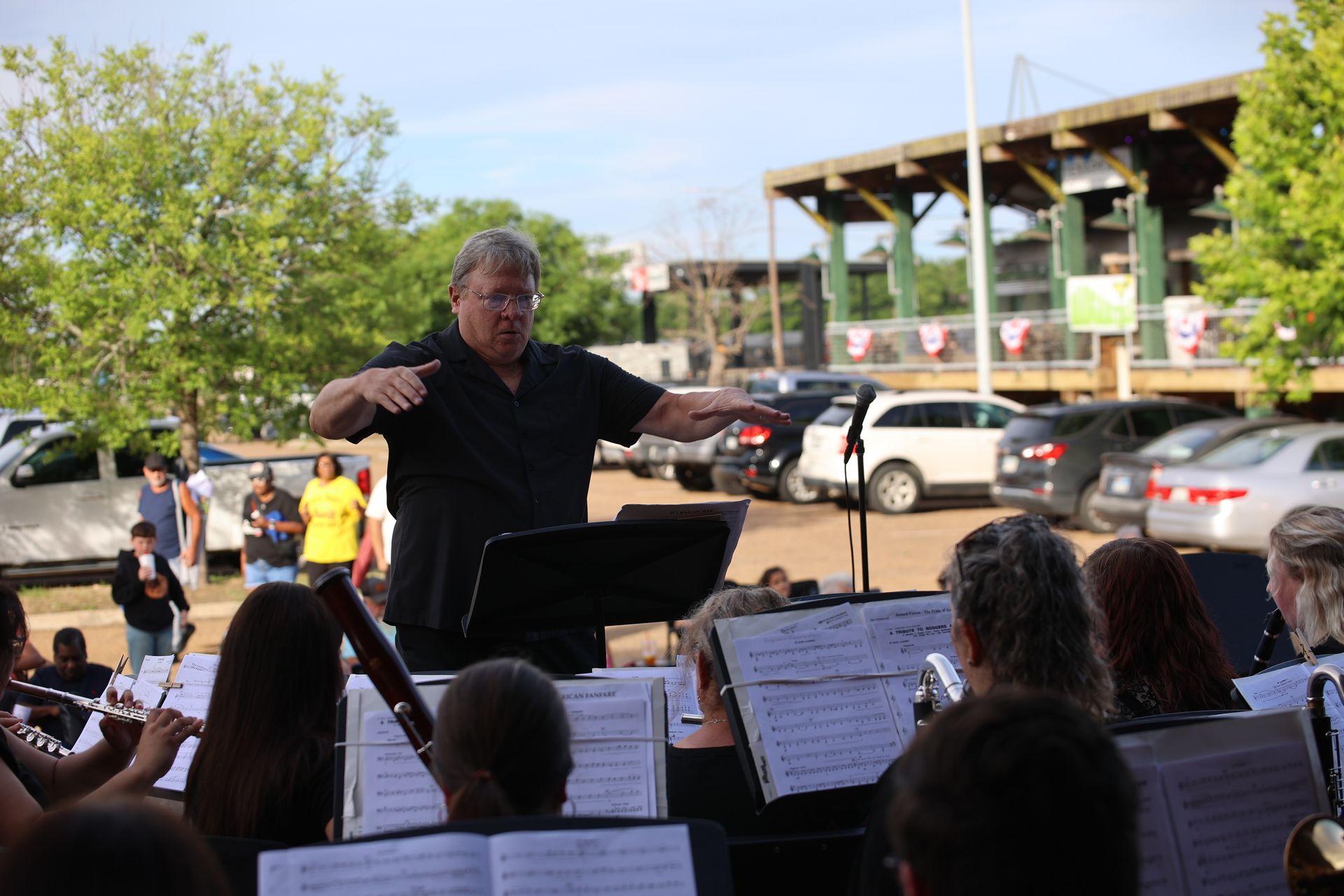 Conductor leading an outdoor orchestra performance in downtown Texarkana during Downtown LIVE