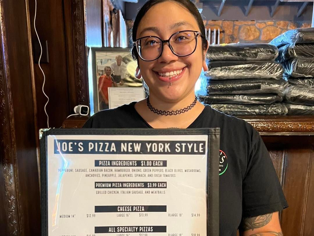 Woman smiling, holding a menu for 