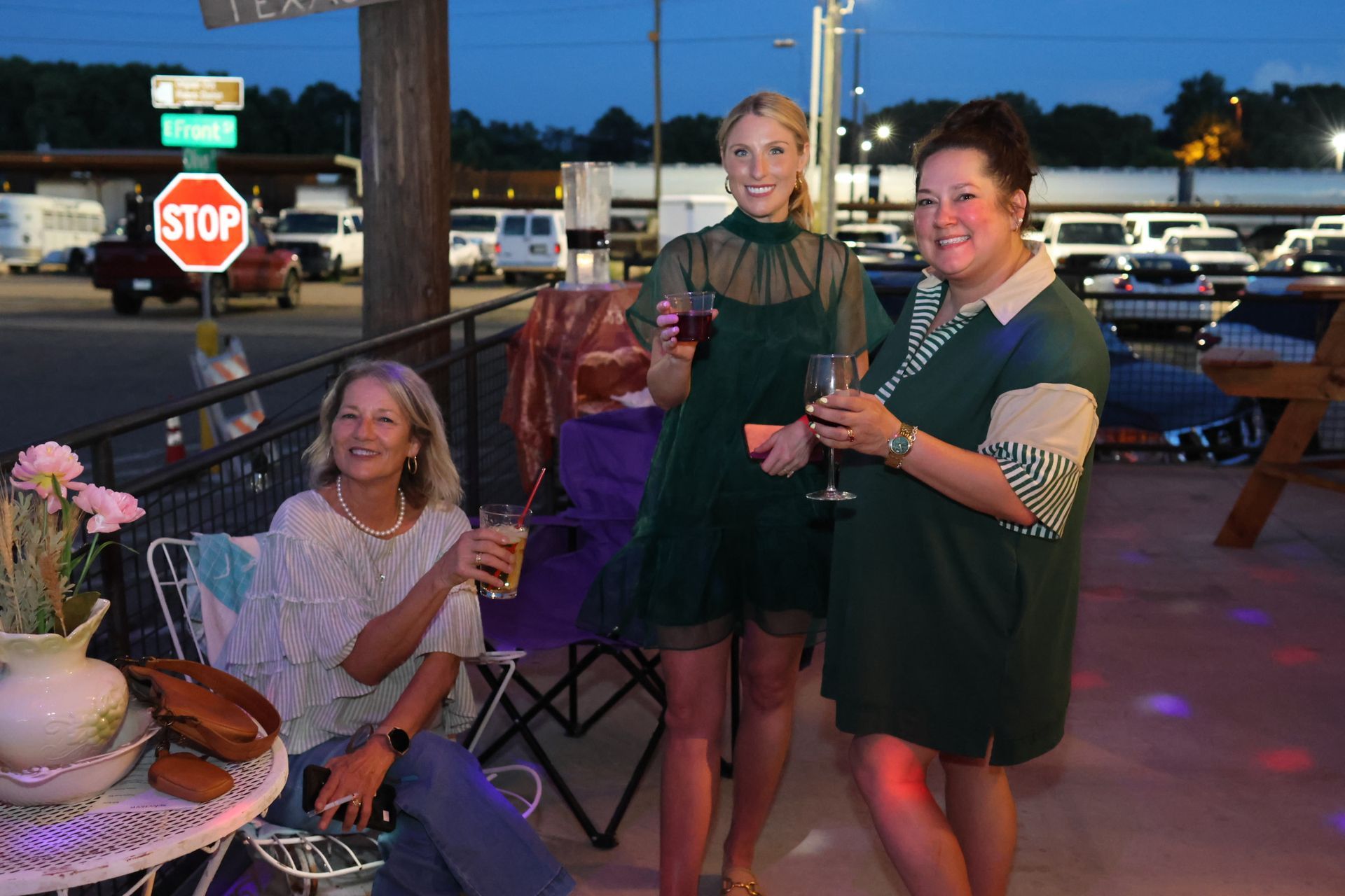 People raising drinks at an outdoor patio gathering in downtown Texarkana during Downtown LIVE