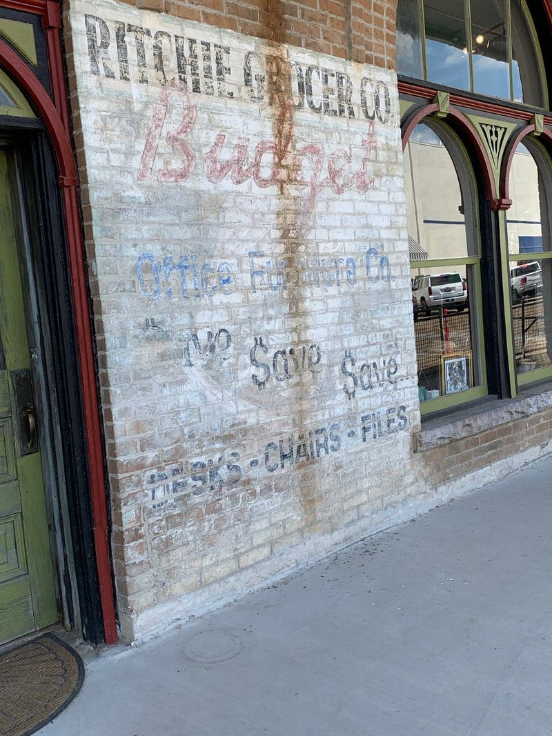 Old brick building with faded signage: