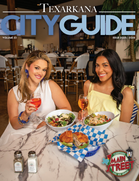 Texarkana City Guide cover: Two women smiling, dining with food and drinks at a table.