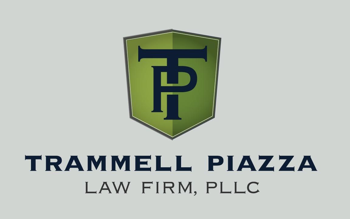 Logo of Trammell Piazza Law Firm; a dark green shield with