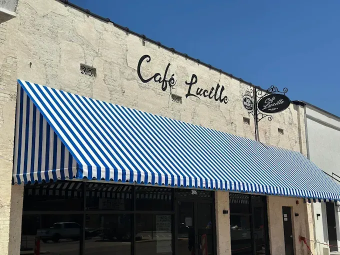 Cafe Lucille storefront with blue and white striped awning.