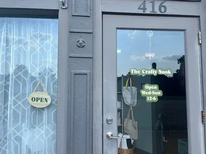 Gray storefront door with “The Cozy Book” sign, open/closed hours posted, and the number 416 above.