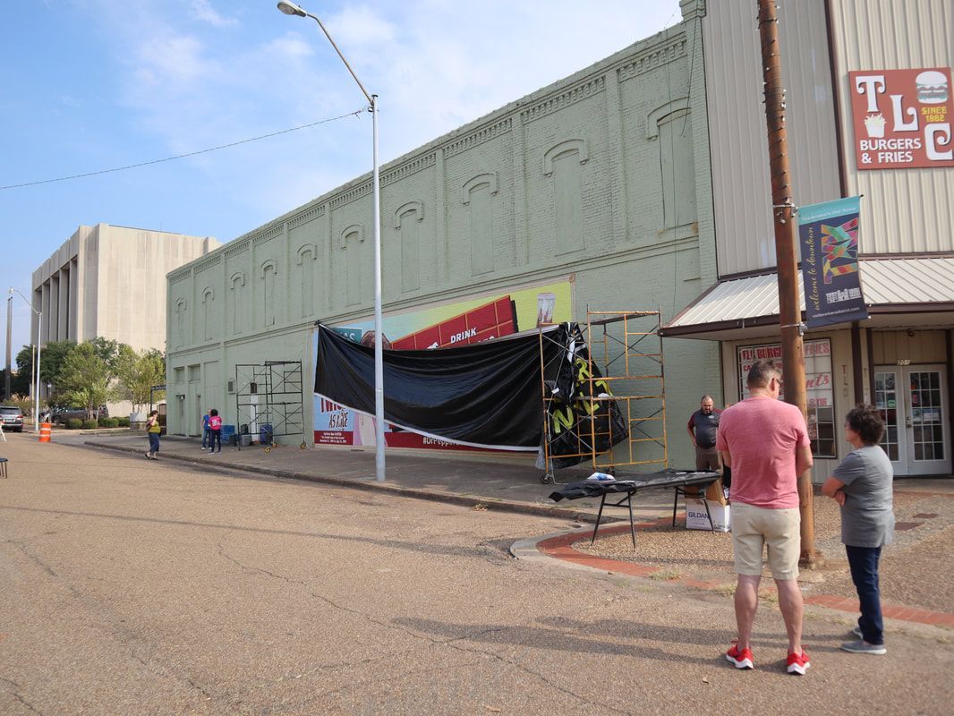 Street view with people, scaffolding, a building under construction, and a TLC sign.