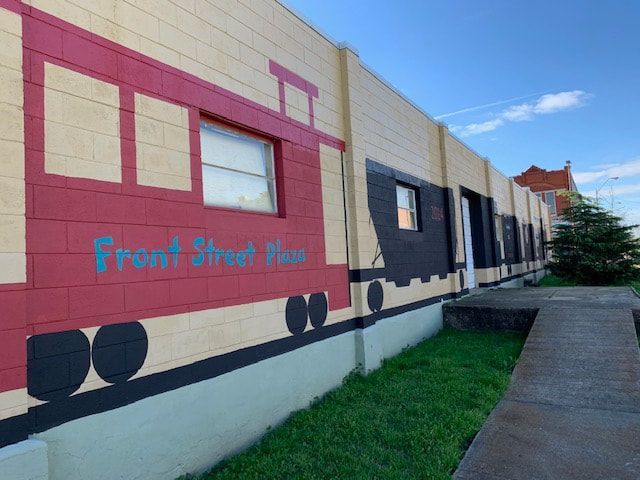 Mural on a building depicts a train with text