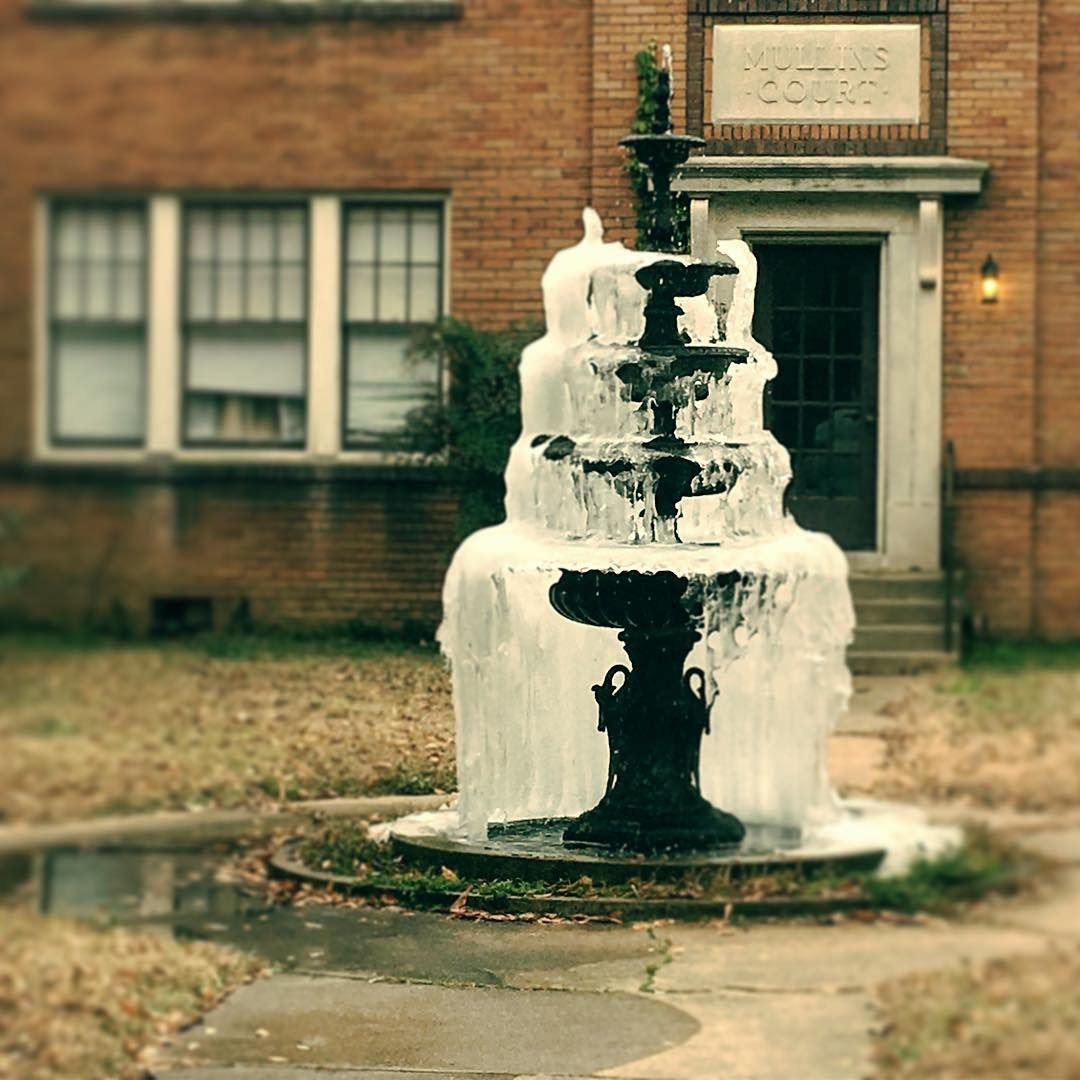 Frozen fountain in front of brick building with
