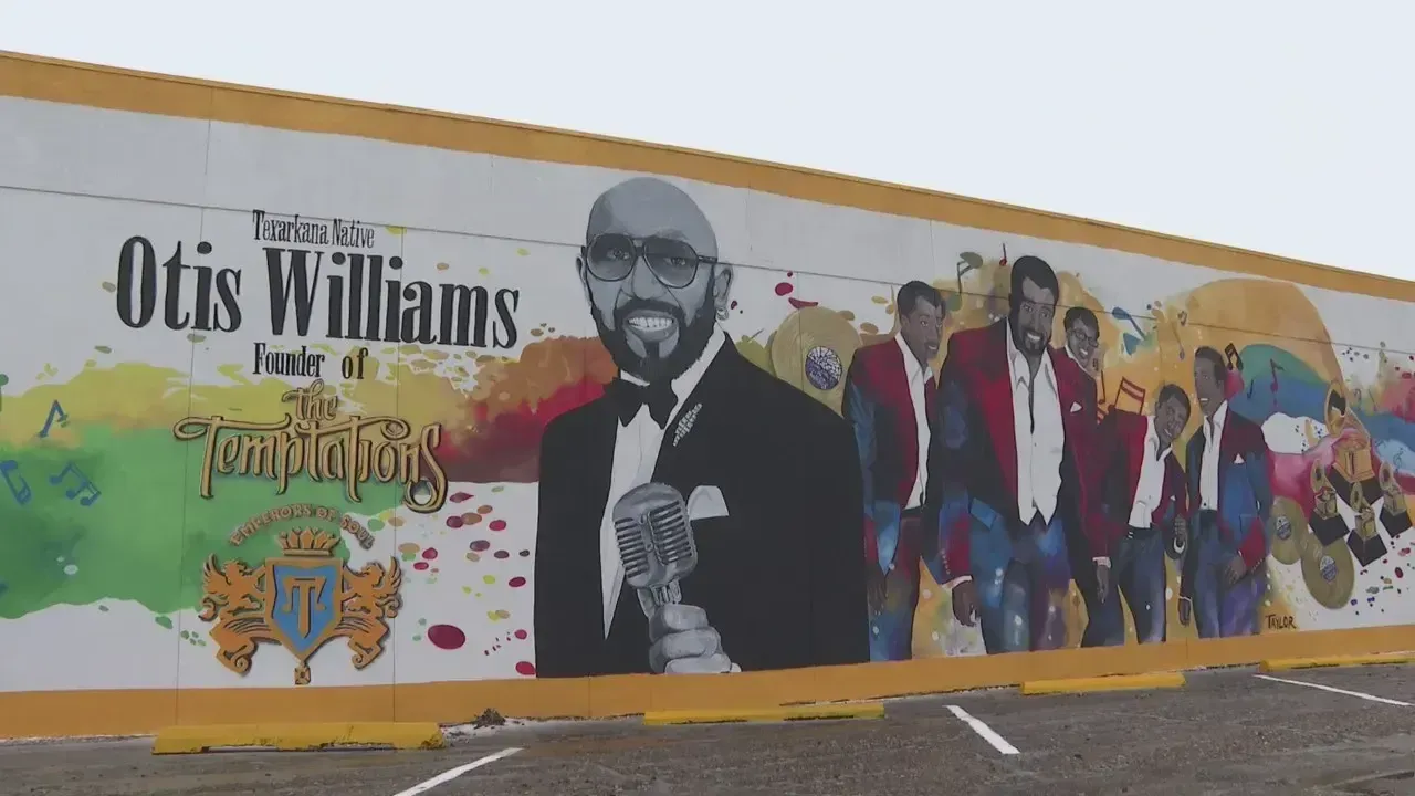 Mural of Otis Williams and The Temptations on a white and yellow wall, with colorful accents.