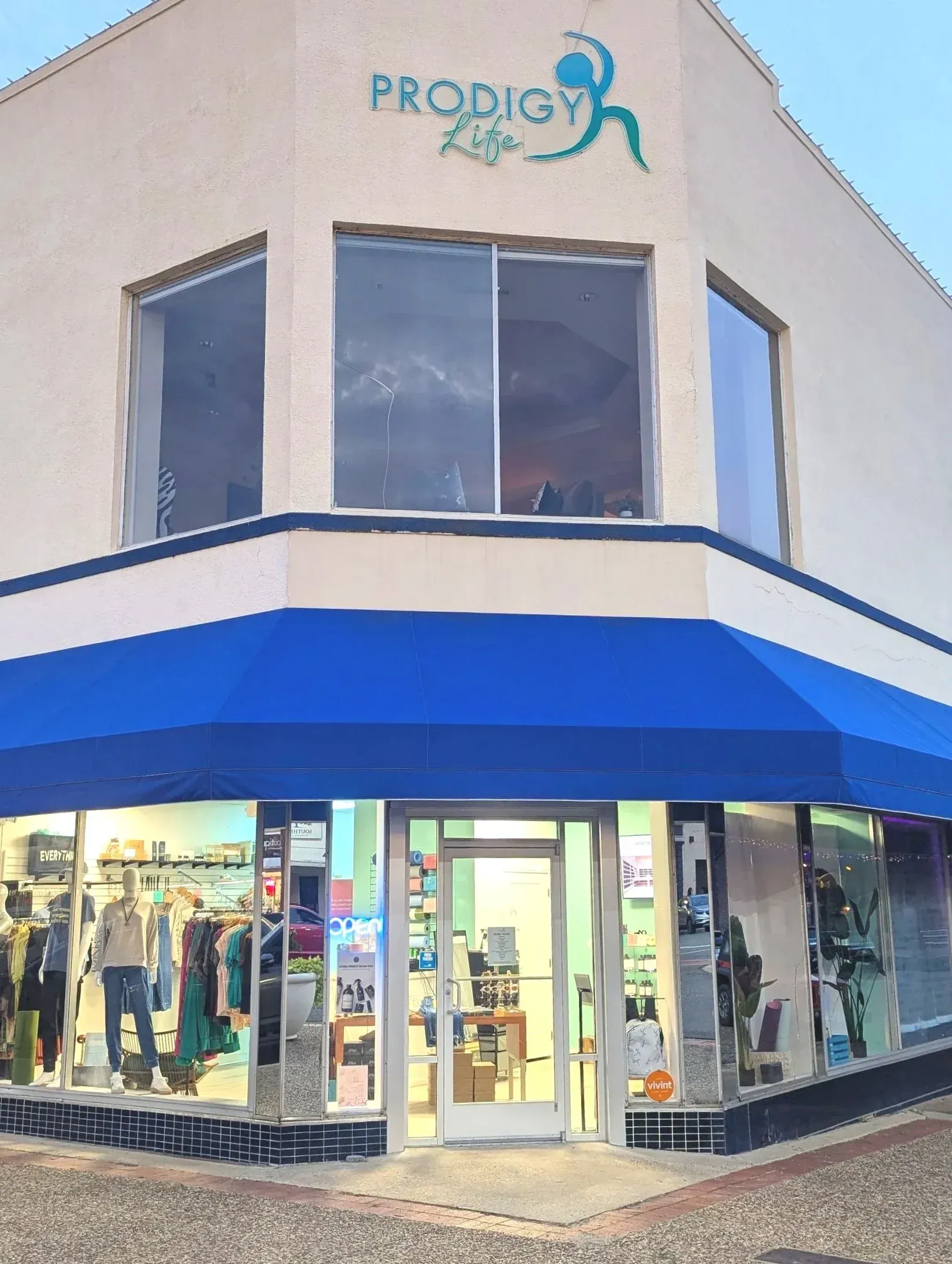 Corner storefront with blue awning,