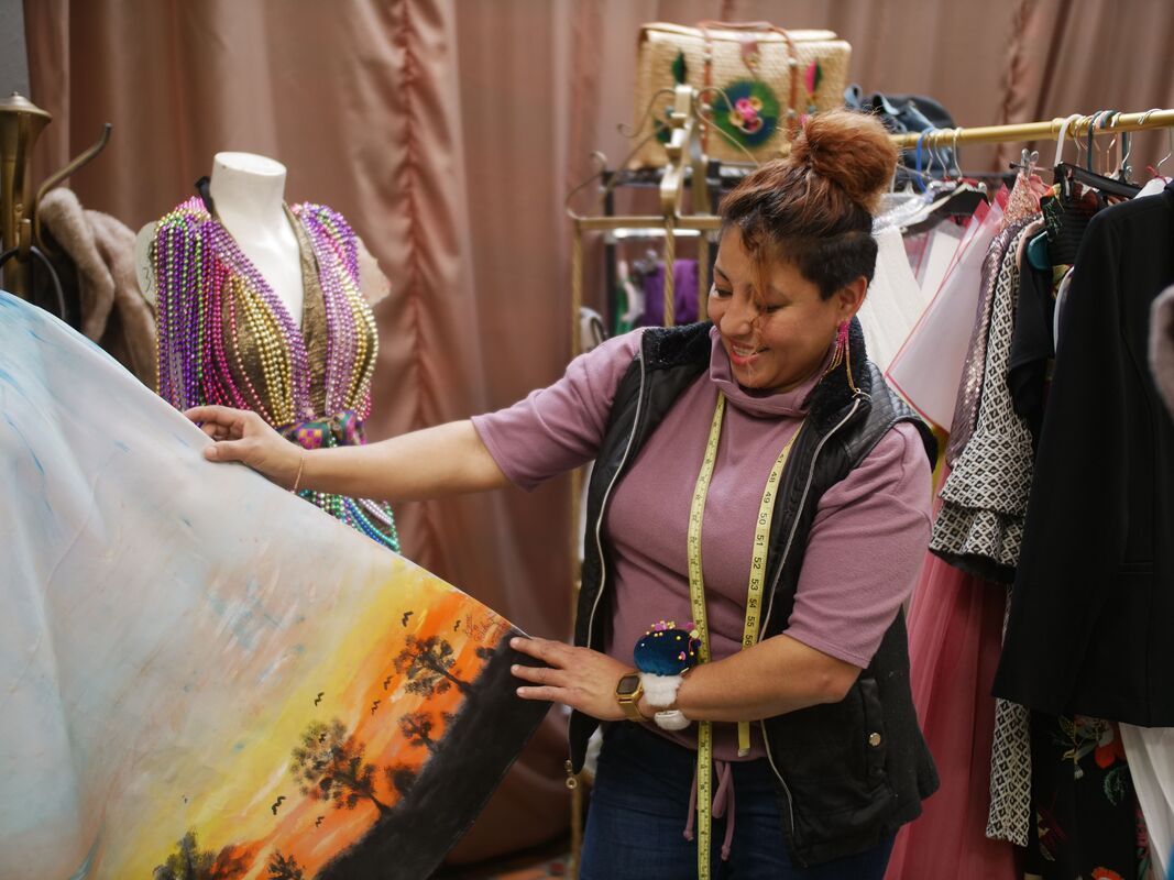 Woman examining fabric with printed design in clothing shop.