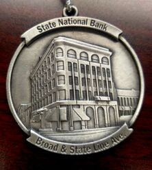 Silver medallion with State National Bank building on Broad & State Line Ave.