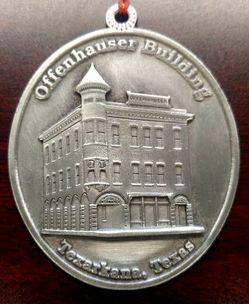 Silver medallion depicting the Offenhauser Building in Texarkana, Texas.