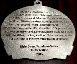 Medallion engraved with text about Texarkana, split between Texas and Arkansas, Tenth Edition 2015.