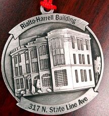Ornament depicting the Rialto-Harrell Building at 317 N. State Line Ave. It is silver with a red hanging string.