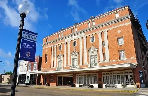 Red brick building with white columns and a banner that reads