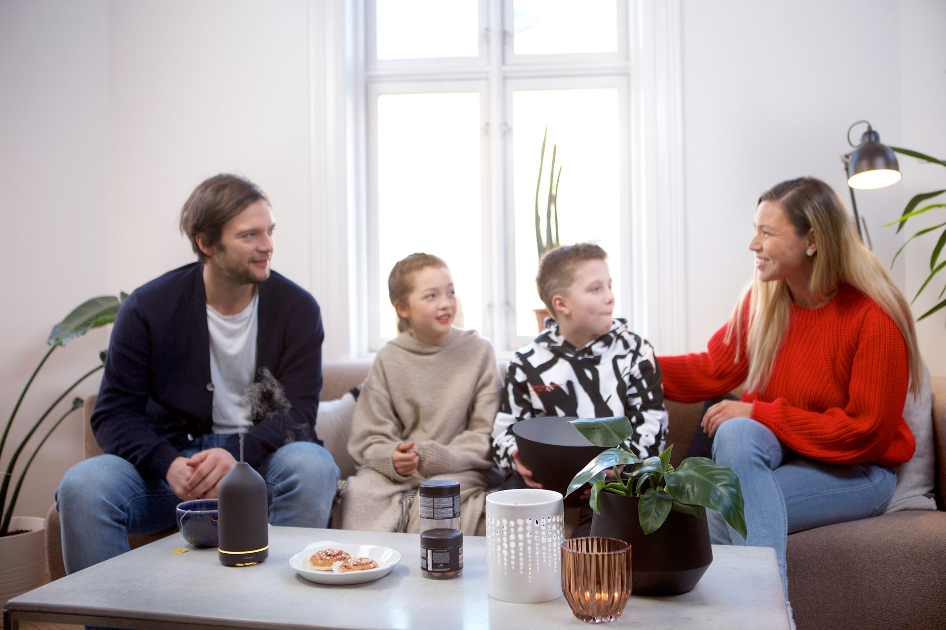 Vader, moeder, dochter zoon op de bank in een woonkamer