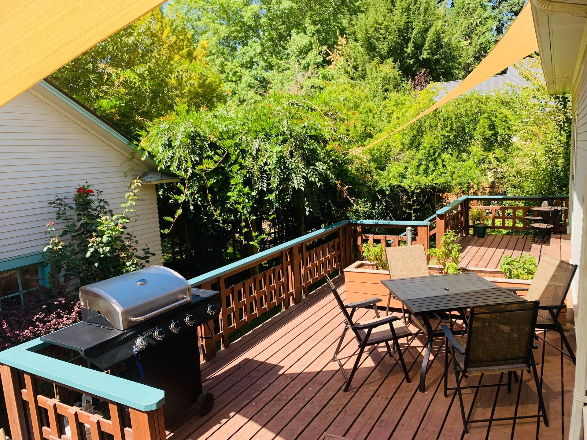 A deck with a table and chairs and a grill