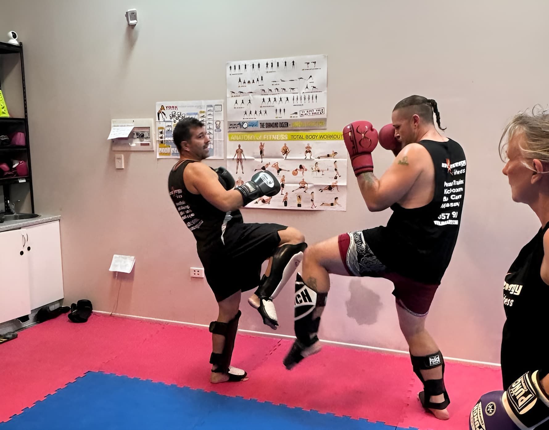 Two Men Are Kickboxing In A Gym While A Woman Watches — Maxenergy Fitness In Smithfield, QLD