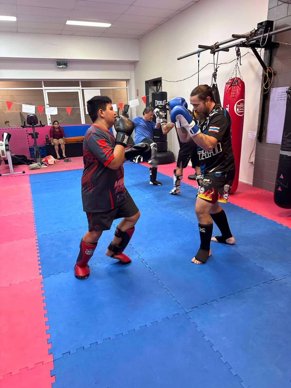 A Group Of Men Are Boxing On A Mat In A Gym — Maxenergy Fitness In Smithfield, QLD