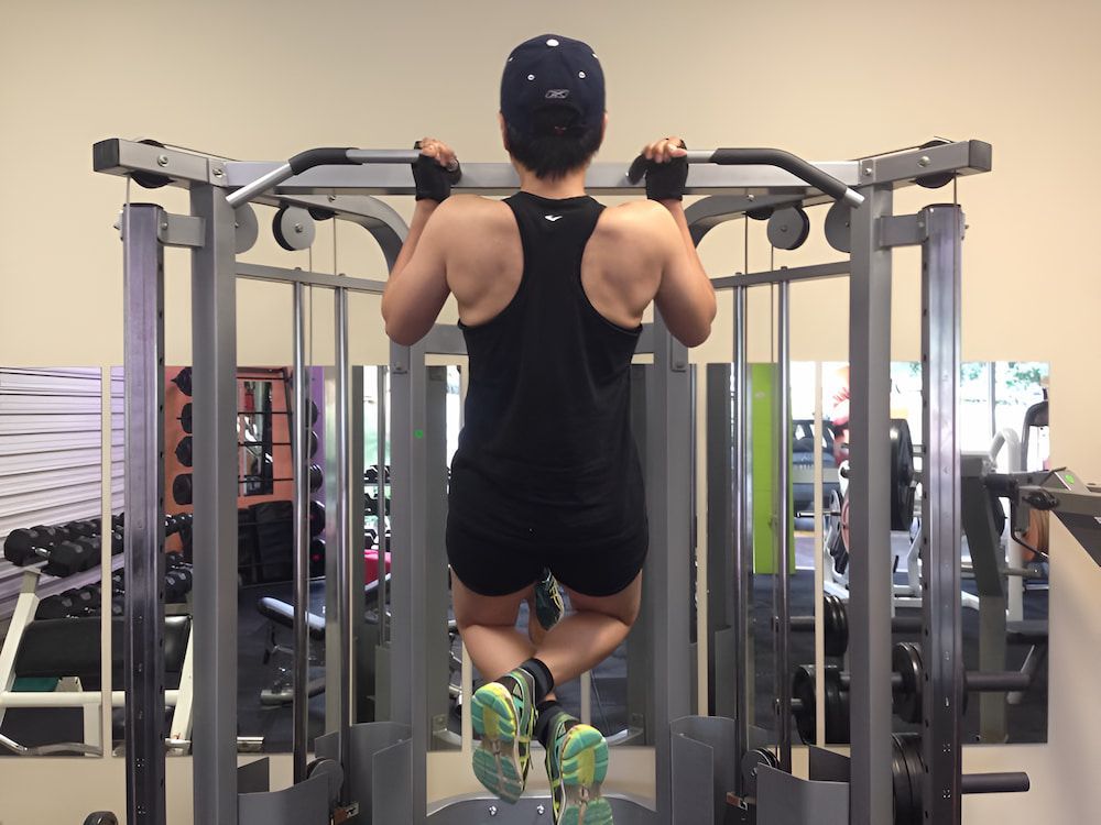 A Man Is Doing A Pull Up In A Gym — Maxenergy Fitness In Smithfield, QLD
