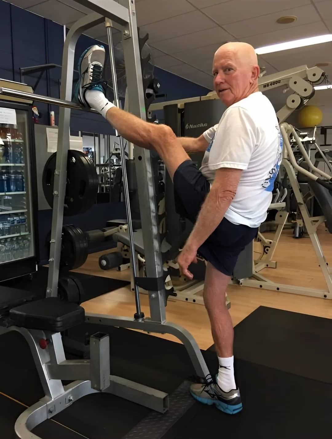 An Older Man Is Doing Leg Exercises On A Machine In A Gym — Maxenergy Fitness In Smithfield, QLD