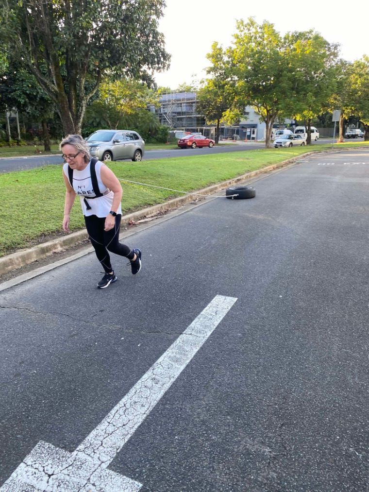 A Woman With A HArness On Pulling A Tyre On The Side Of The Road — Maxenergy Fitness in Smithfield, QLD